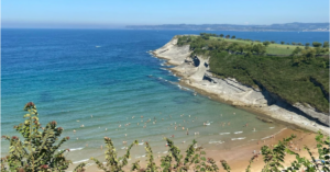 Beach view of clear blue waters, a sandy beach, and a clear light blue sky