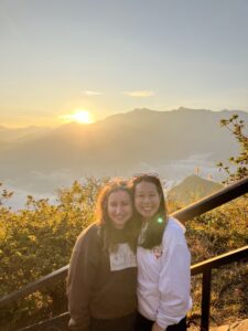 Photo of two female students smiling in long sleeve shirts