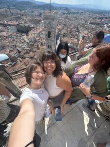 Two students post for a selfie on top of a platform that overlooks Florence