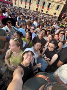 Students wait in a crowded plaza and take a selfie to pass the time.