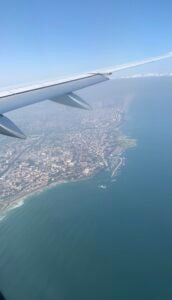 The view of a city and it's coast line from an airplane window.