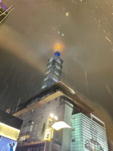 A large building stands tall during a rainy day at night