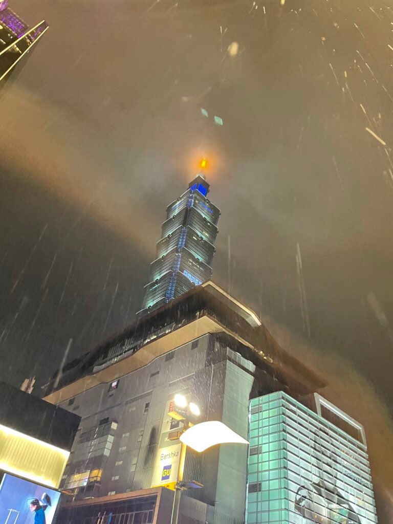 A large building stands tall during a rainy day at night