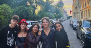 Students posing in front of the Eiffel Tower during the sunrise in Paris.