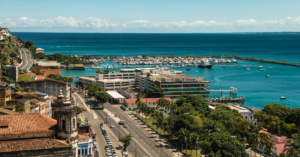 A city in Latin America on the coast with clear, blue water and businesses off the coast.