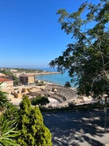 View of the Tarragona Amphitheater from a higher vantage point which sits on the side of the beach on a sunny day