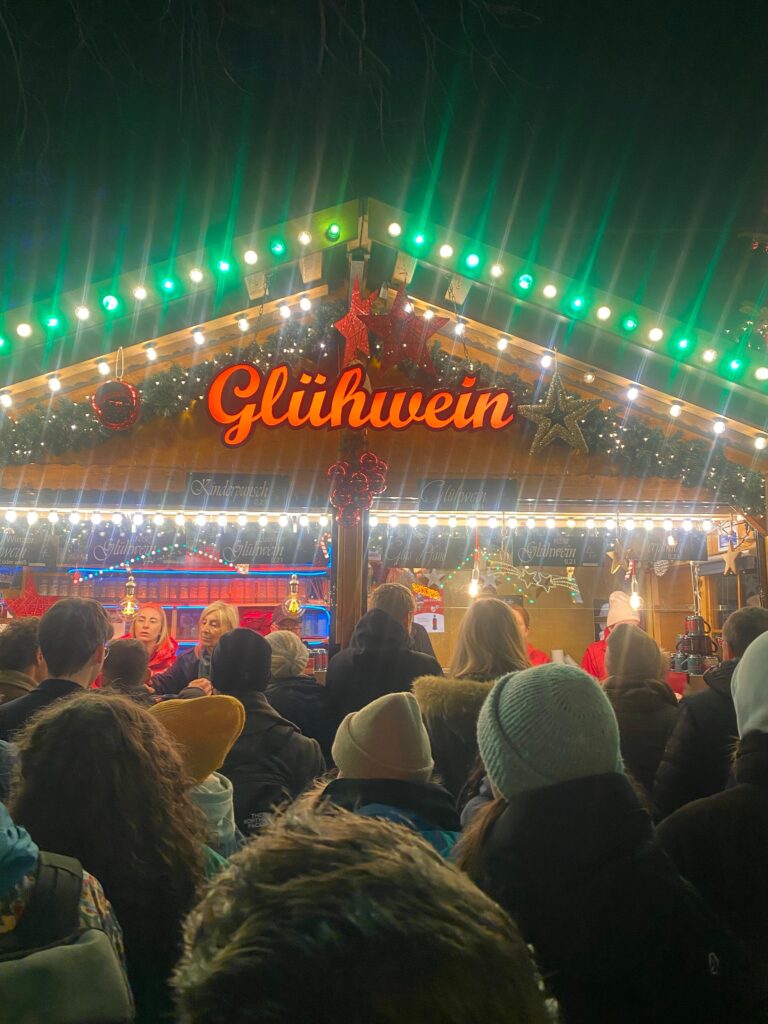 An image of the german word, "gluhwein" advertises a popular tent at a holiday market in Germany