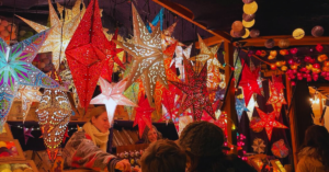 Many Star Christmas lights at a holiday market illuminate the stall