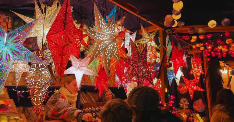 Many Star Christmas lights at a holiday market illuminate the stall