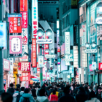 A busy street in Tokyo is filled with loud digital advertising and tall buildings