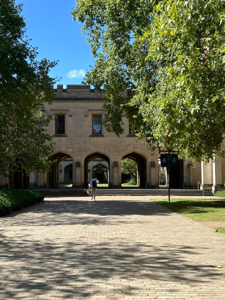 An old campus building that has windows and opening for pedestrians