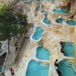 pools carved into a mountain overlook a vast mountain range