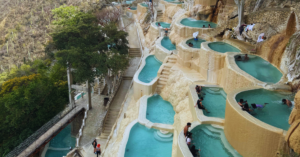 pools carved into a mountain overlook a vast mountain range