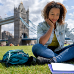 A student studying while sitting in a park in London