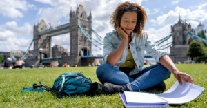 A student studying while sitting in a park in London