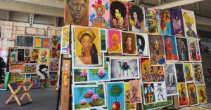 Several art photos of canvas paintings in a building.
