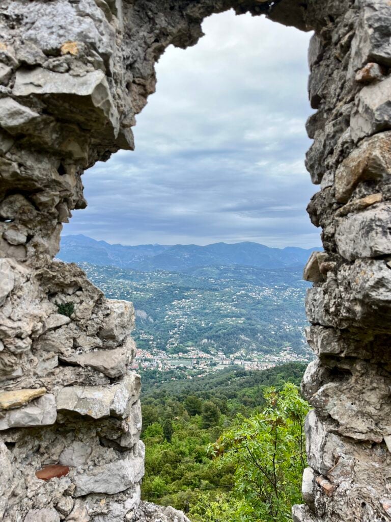 Two large rock structures frame either side of a city in the distance.