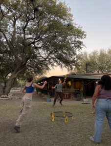 Three students play a game of Spikeball outdoors