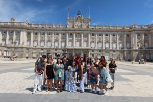 A large group of students outside of Madrid's historic palace.