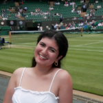 Student in all white smiles at the camera while at Wimbledon.