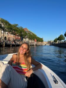 student smiles while taking a boat ride in Copenhagen.