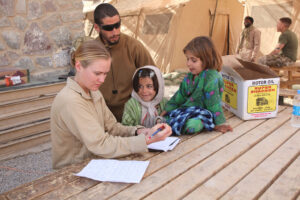 A group four people, two adults and two young children filling out paperwork.