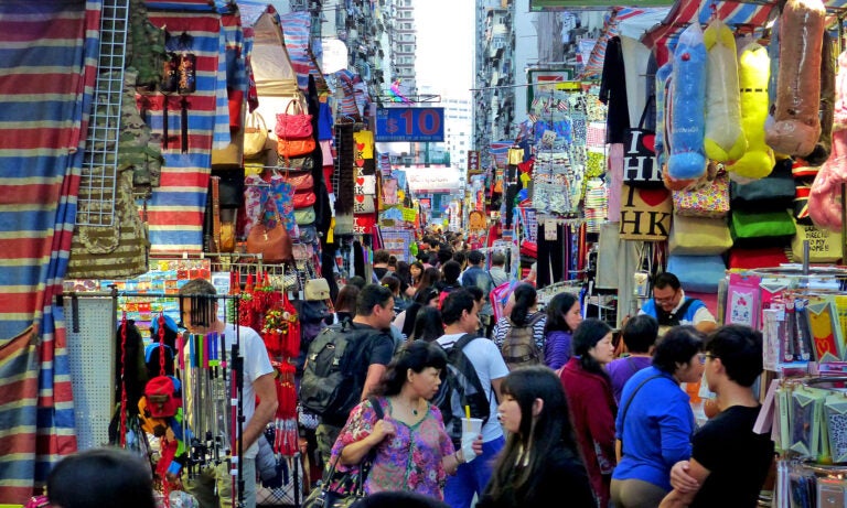 A busy street filled with tourists and outdoor shops.