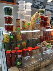 Clear tubs of pickled food on display at an open air market