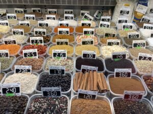 Clear tubs of spices on display at an open air market