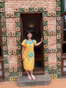 A student in a green dress while posing.