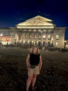 Student smiles in front of a large monument building in Germany.