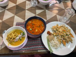 Three authentic Asian dishes consisting of two soups and one plate of noodles and rice.