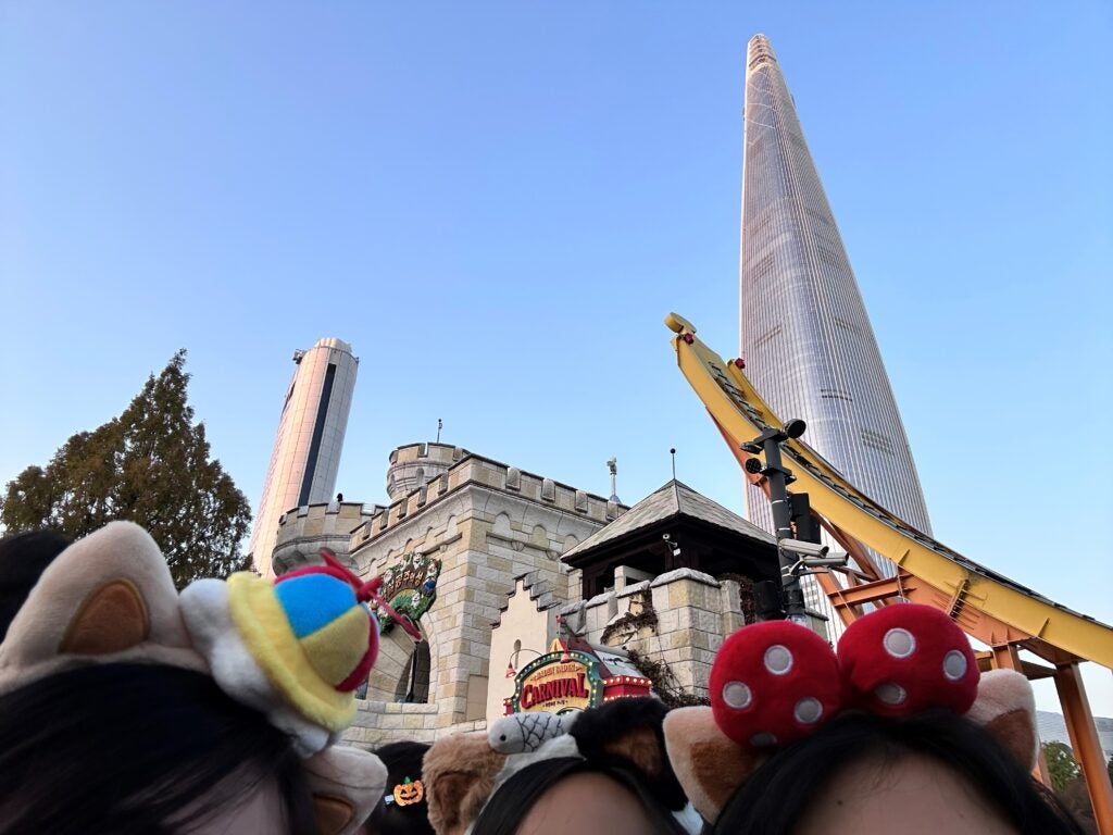 Looking above the heads of the crowds, some buildings can be seen in Lotte World