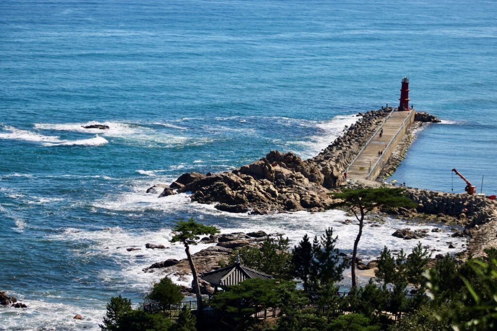 A view of the The Sokcho Sea coast with a natural stone formed causeway to a small lighthouse