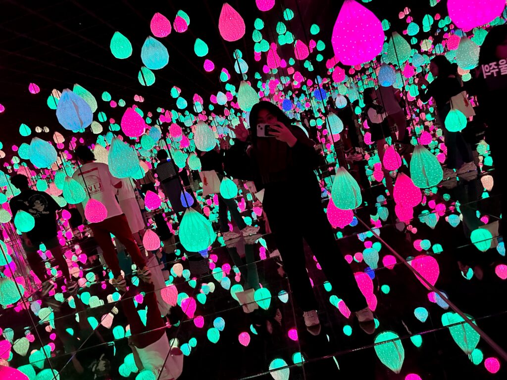 A selfie at a unique art exhibit with colorful neon hanging lights in the dark at Arte Museum Gangneung