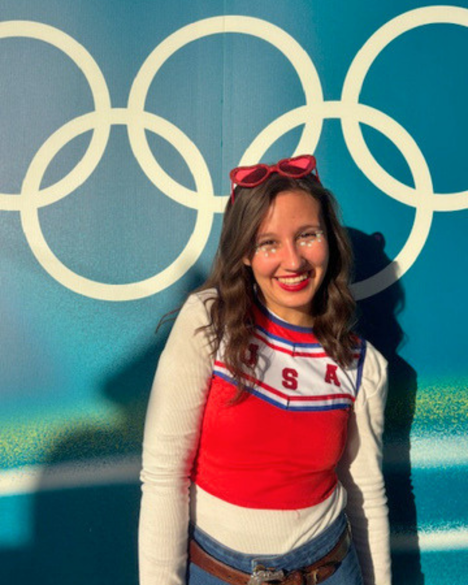 Standing in front of the Olympic rings display.