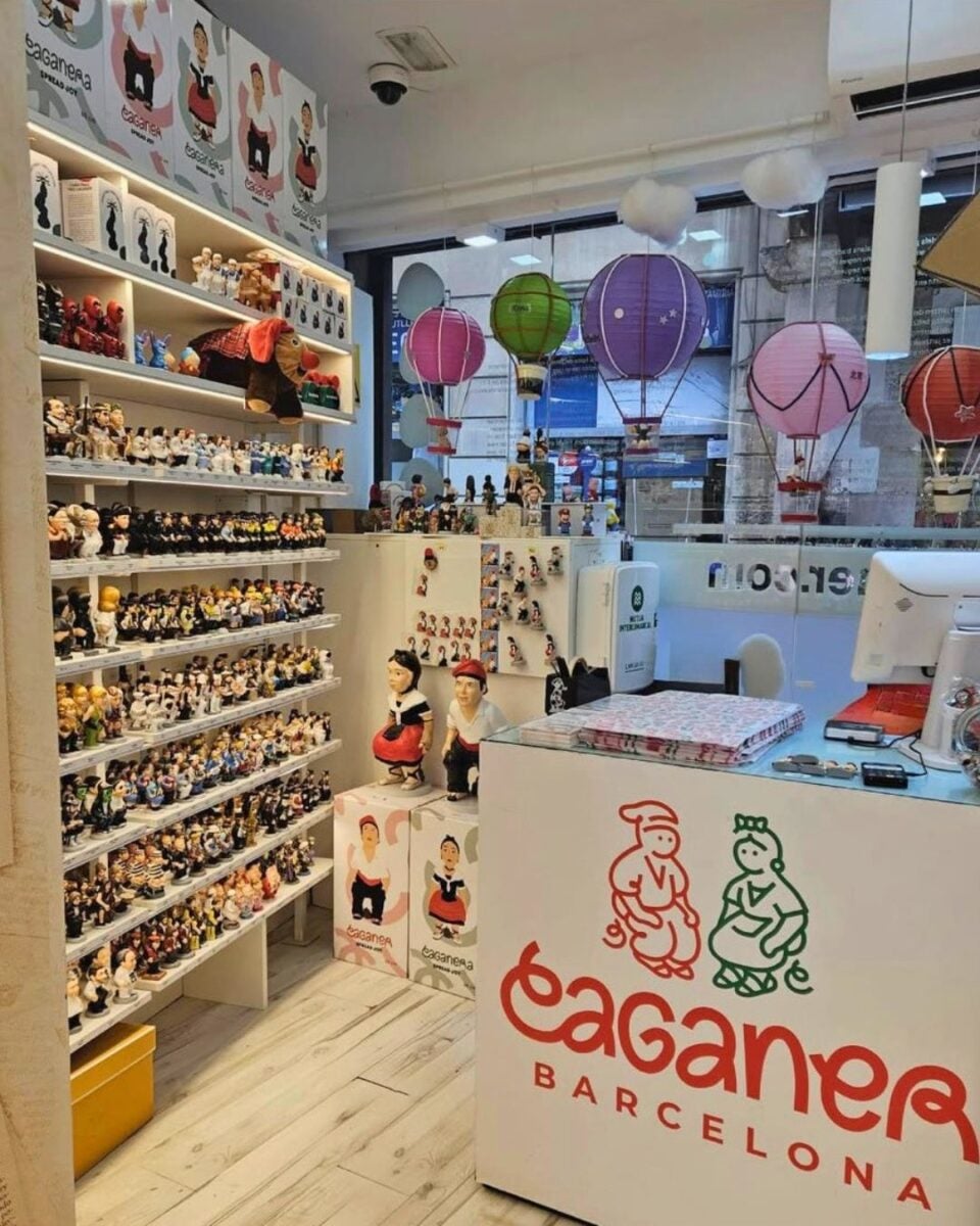 Interior of a Barcelona shop filled with traditional figurines and colorful hot air balloon decorations hanging from the ceiling.